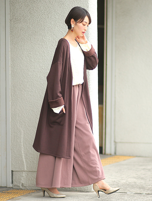 白のトップスとピンクベージュのワイドパンツのコーデに、ロングカーディガンを羽織った女性