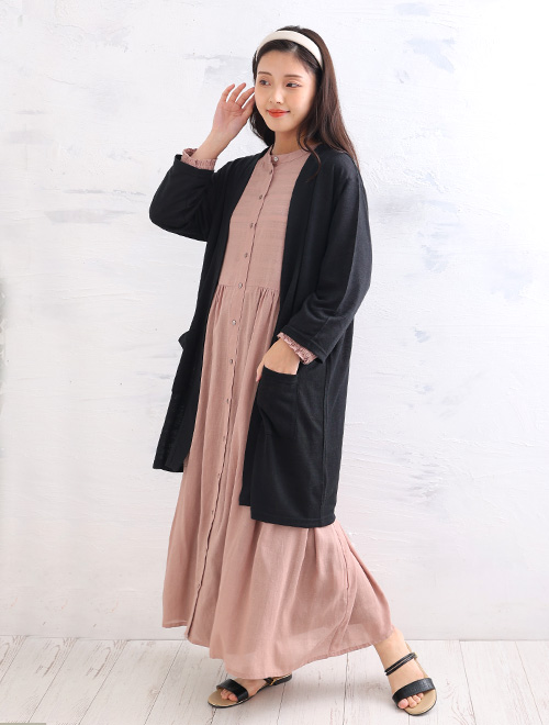 ピンクのシャツワンピースに、黒のロングカーディガンを羽織った女性
