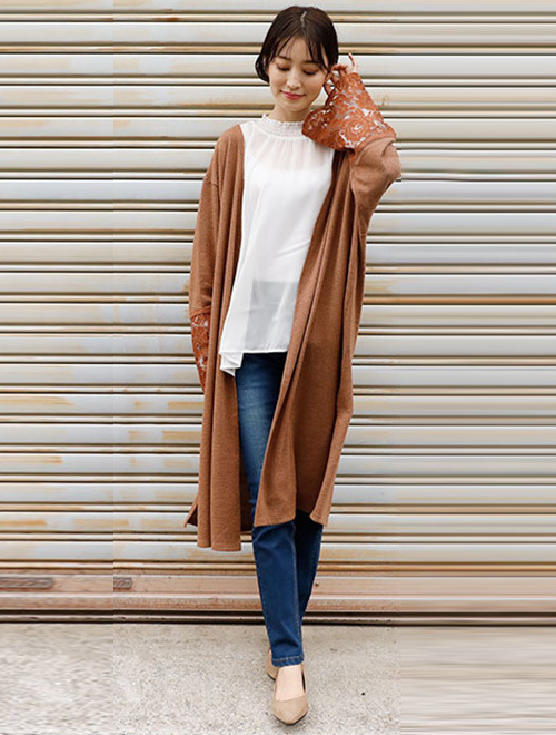 シアーブラウスとデニムのコーデに、袖レースのロングカーディガンを羽織った女性