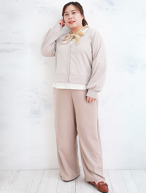 ショート丈のカーディガンを着て、ワイドパンツを履く女性