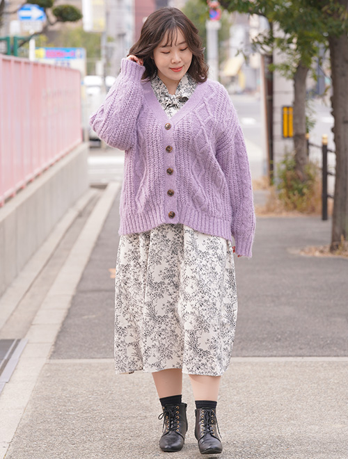 小花柄のワンピースを着て、パープルのローゲージニットカーディガンを羽織った女性