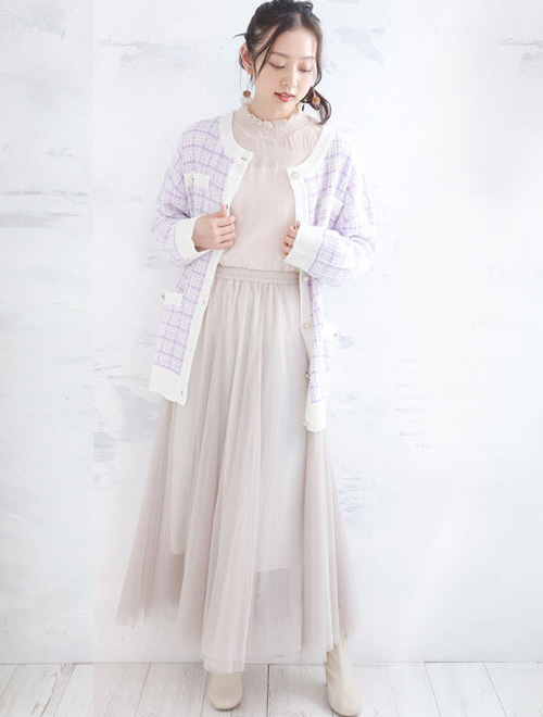 チュールワンピースに、パープル×白のツイードカーディガンを羽織った女性