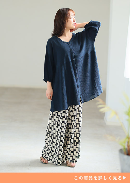 ネイビートップスを着て、柄のあるのパンツを履く女性