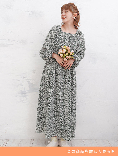 グリーンの小花柄ワンピースを着る女性