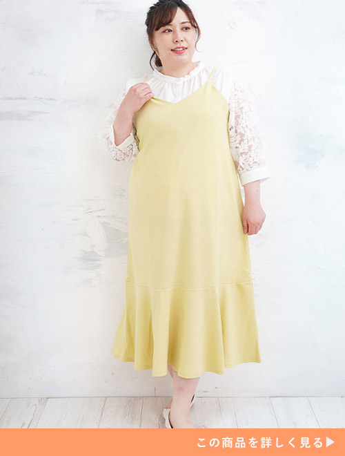 白のレースブラウスに黄色のマーメイドキャミワンピを重ね着する女性