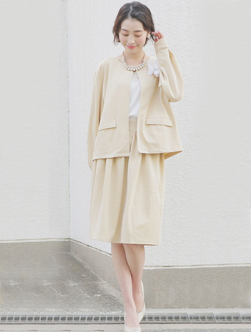 ベージュのカジュアルスーツを着る女性