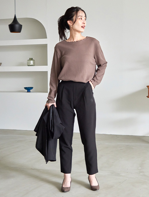 ボートネックのリブカットソーをテーパードパンツにタックインした女性