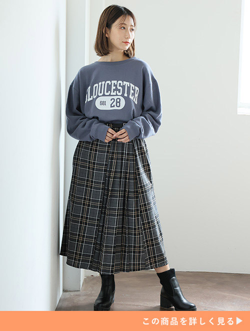 スモークブルーのスウェットを着て、グレー系のチェック柄スカートを履く女性