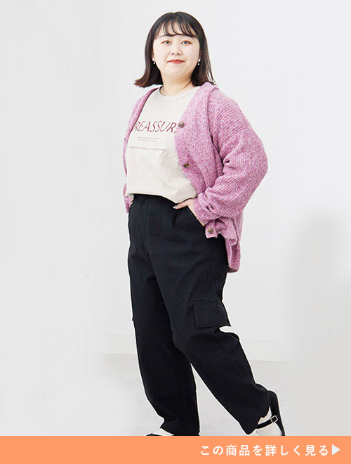 ベージュ系Tシャツ×黒カーゴパンツにピンク色のカーディガンを羽織る女性