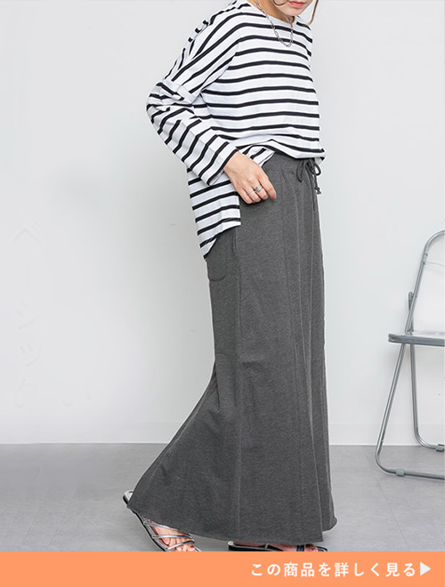 チャコールグレーのセミタイトマキシスカートにボーダートップスを合わせる女性