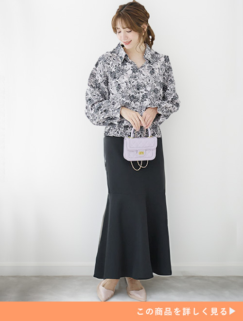 花柄ブラックのシャツにブラックのマーメイドスカートを合わせる女性