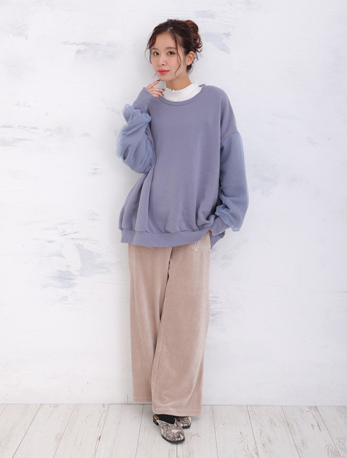 パープルのトップスとピンクのボトムスを着た女性