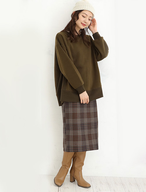 ブラウンのトップスとチェックのスカートを履いた女性