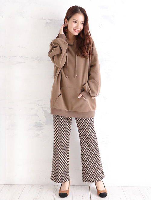 ブラウンのパーカーとフレアボトムスを履いた女性