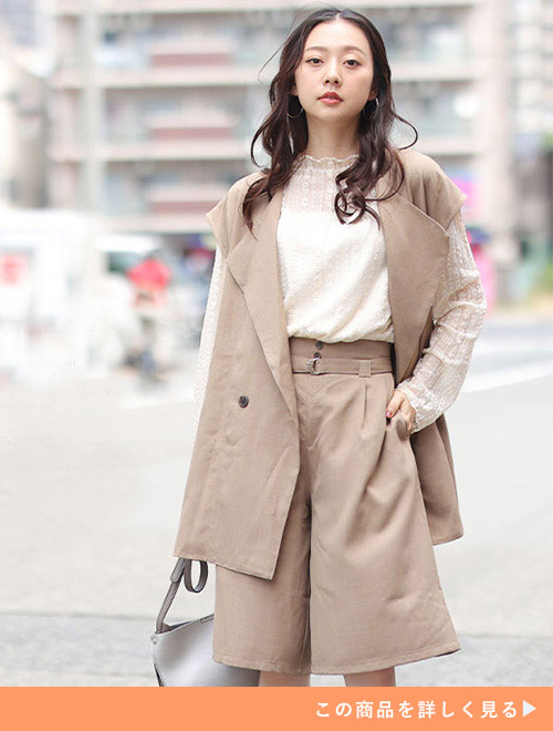 右手で鞄を持ち左手をポケットに入れてポーズを決める女性