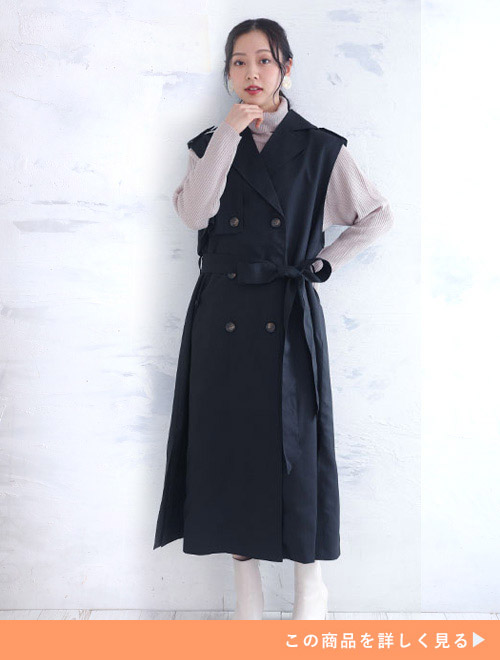 くすみカラーのハイネックに、ブラックのトレンチデザインのジレを着た女性