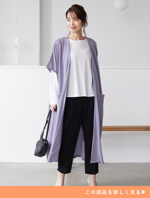 黒のパンツ×白のトップスコーデにラベンダーカラーのジレを羽織った女性