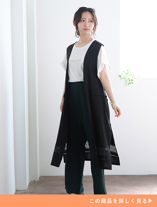 黒のロングジレをモノトーンパンツコーデに合わせた女性