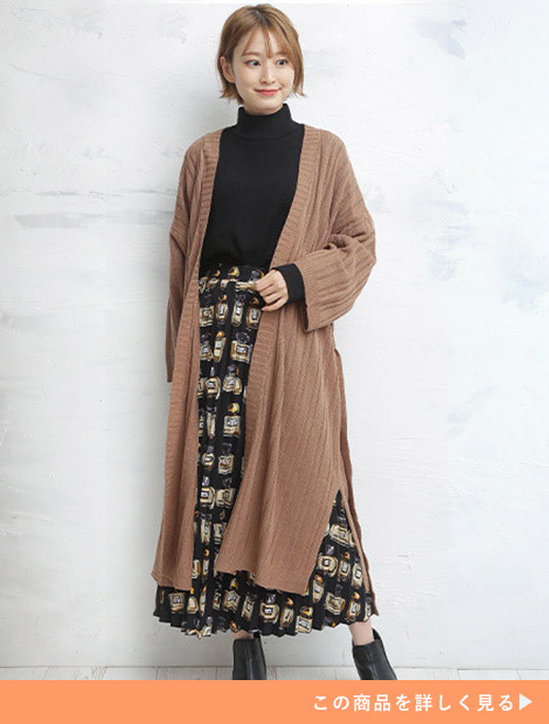 黒トップス×柄スカートにブラウンのロングカーディガンを着た女性