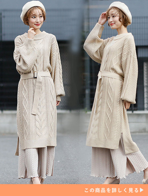 ベージュのニットワンピースにベージュスカートをレイヤードした女性
