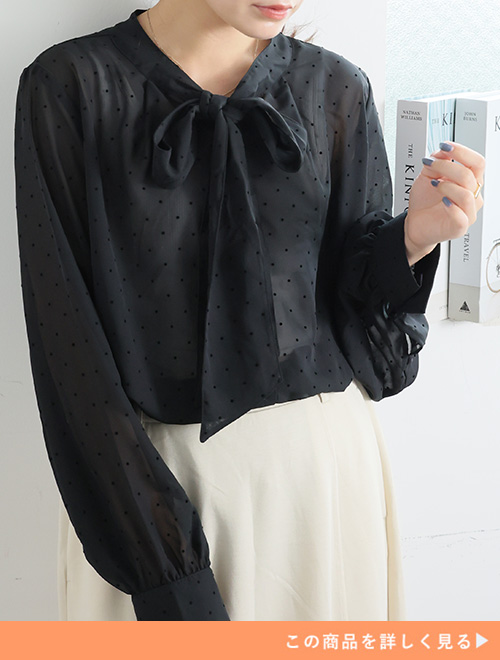 黒のドット柄シフォンブラウス×アイボリーのスカートを着る女性