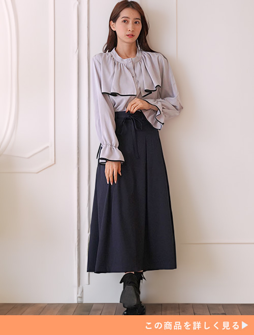 アイスグレーのブラウス×ネイビーのスカートを着る女性