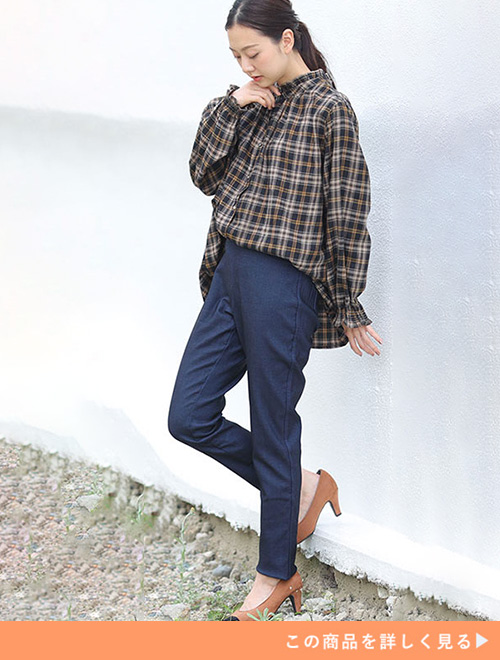 オーバーサイズのチェック柄ブラウス×スキニーパンツを着る女性