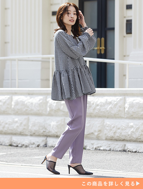 ギンガムチェック柄のペプラムブラウス×パープルのテーパードパンツを着る女性