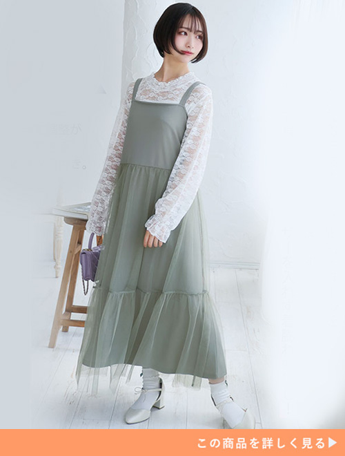 白のレーストップスにライトグリーンのチュールキャミワンピを重ね着する女性