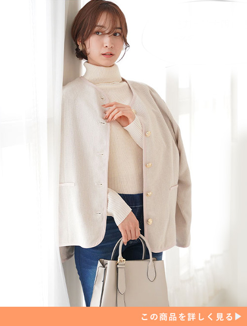 白のタートルネックニット×デニムに、アイボリーのツイードノーカラージャケットを羽織る女性