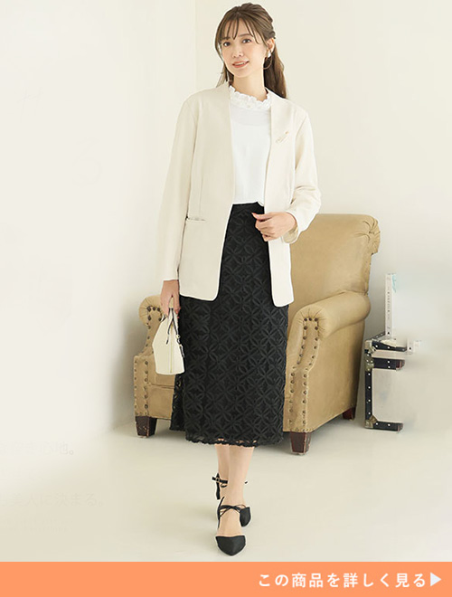 白ブラウス×黒のレーススカートに、白のジャケットを羽織る女性