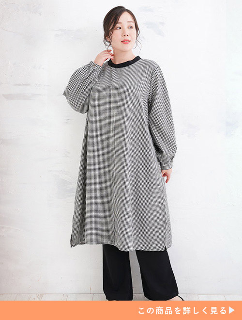 ギンガムチェックのAラインワンピースに黒のワイドパンツをレイヤードして着る女性