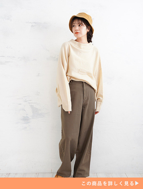 アイボリーのトップスをダークモカ色のワイドパンツにトップスインして着る女性