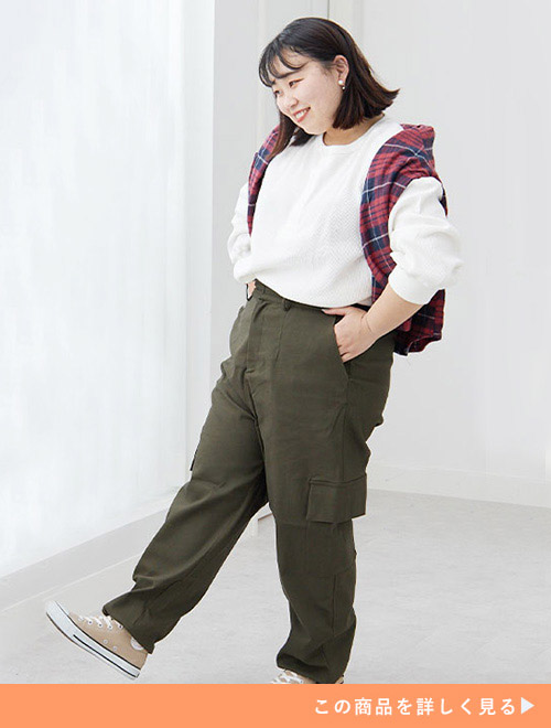 白のロンT×カーキ色のカーゴパンツを着て、赤のチェック柄トップスを肩掛けする女性