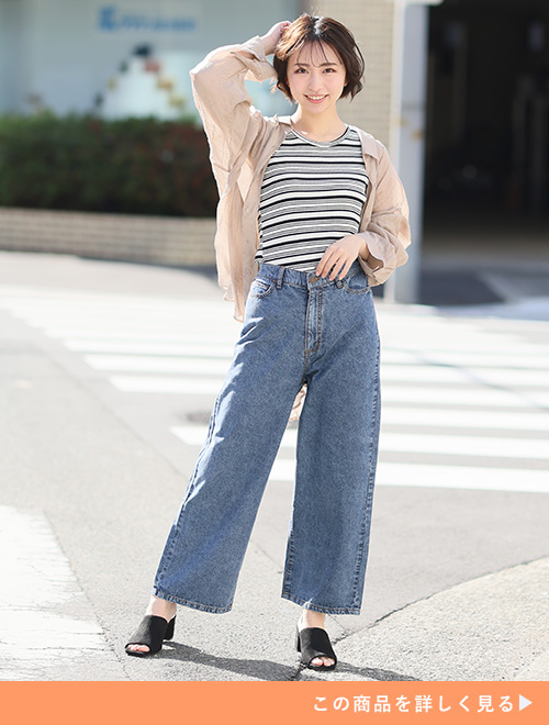 ベージュのシャツにシャツにワイドデニムを穿く女性