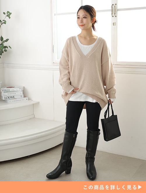 白Tシャツ×黒のスキニーパンツにブラウン系のニットを着る女性