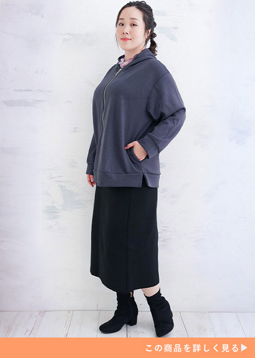 グレーのジップパーカに黒のタイトスカートを合わせた女性