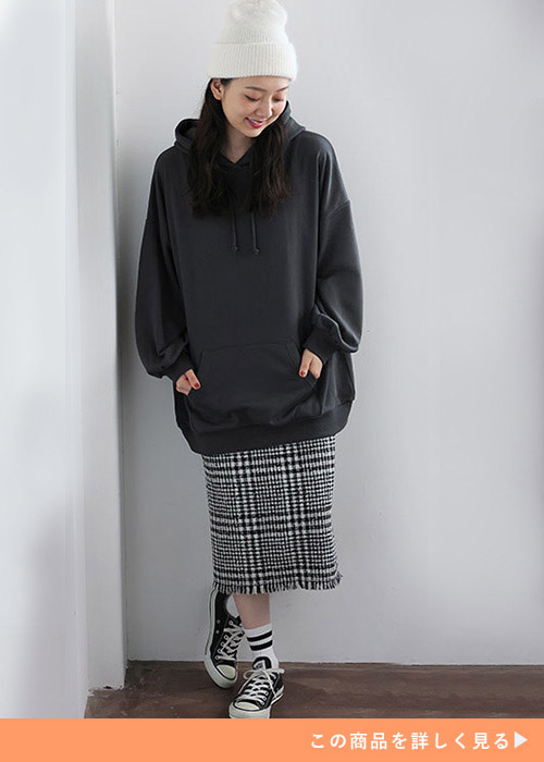 チェックのタイトスカートに黒のパーカを合わせた女性