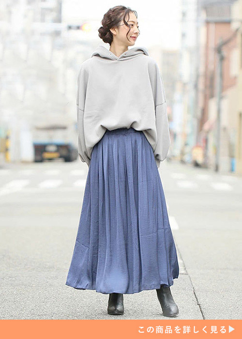 両手を後ろで組んで左を向く女性