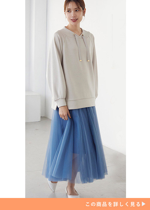 ブルーのチュールスカートにベージュのパーカを合わせる女性