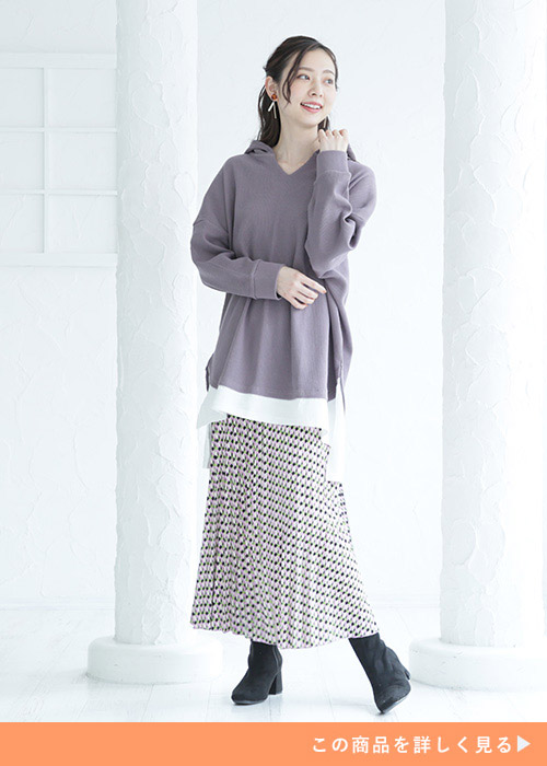 モカカラーのパーカに細めのプリーツスカートを履いた女性