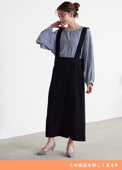 くすみブルーのブラウスを着て、タイトスカートのジャンスカを着る女性