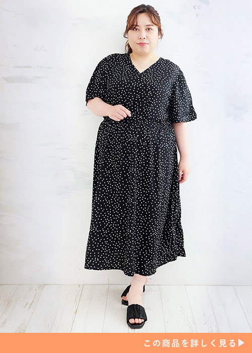 黒字に白のドット柄ワンピースを着る女性