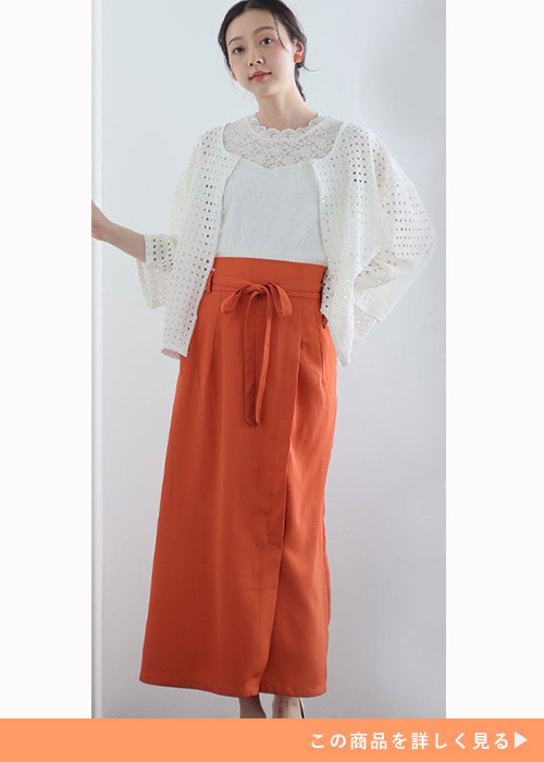 左手を腰に当てて右手を上げてポーズを決める女性