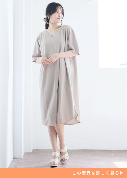 両手を前で組んで左足の踵を上げて左を見る女性