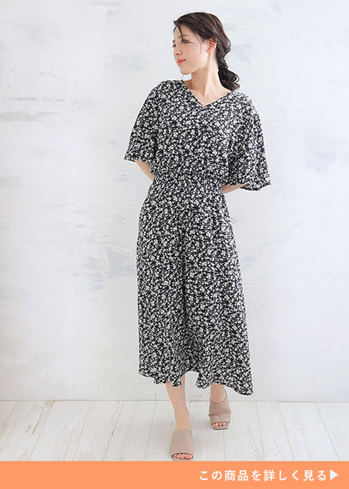 両手を後ろに組んで右側を向く女性