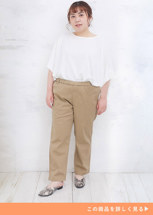 ホワイトのトップスとベージュのパンツのコーデにフラットシューズを履く女性