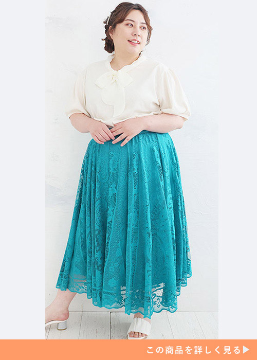 アイボリーのブラウスとレースのAラインスカートに白いサンダルを履く女性