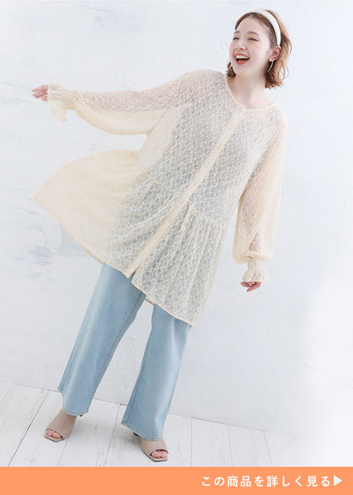 キナリのシャツチュニックとデニムパンツのコーデにサンダルを履く女性