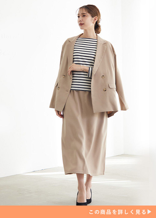 グレージュのダブルボタンジャケットとスカートのコーデにボーダートップスを合わせる女性